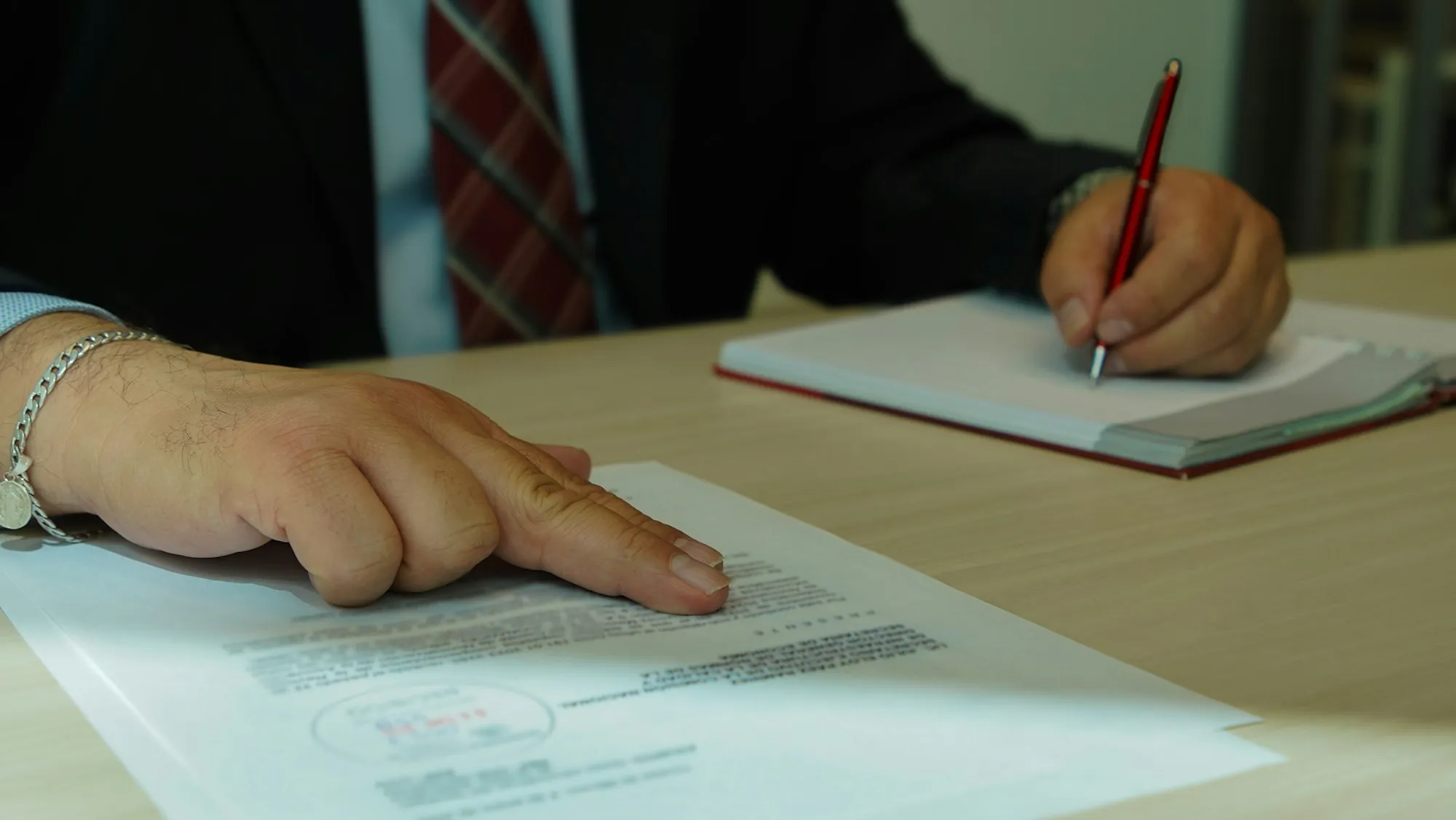 Person pointing to a line on a document