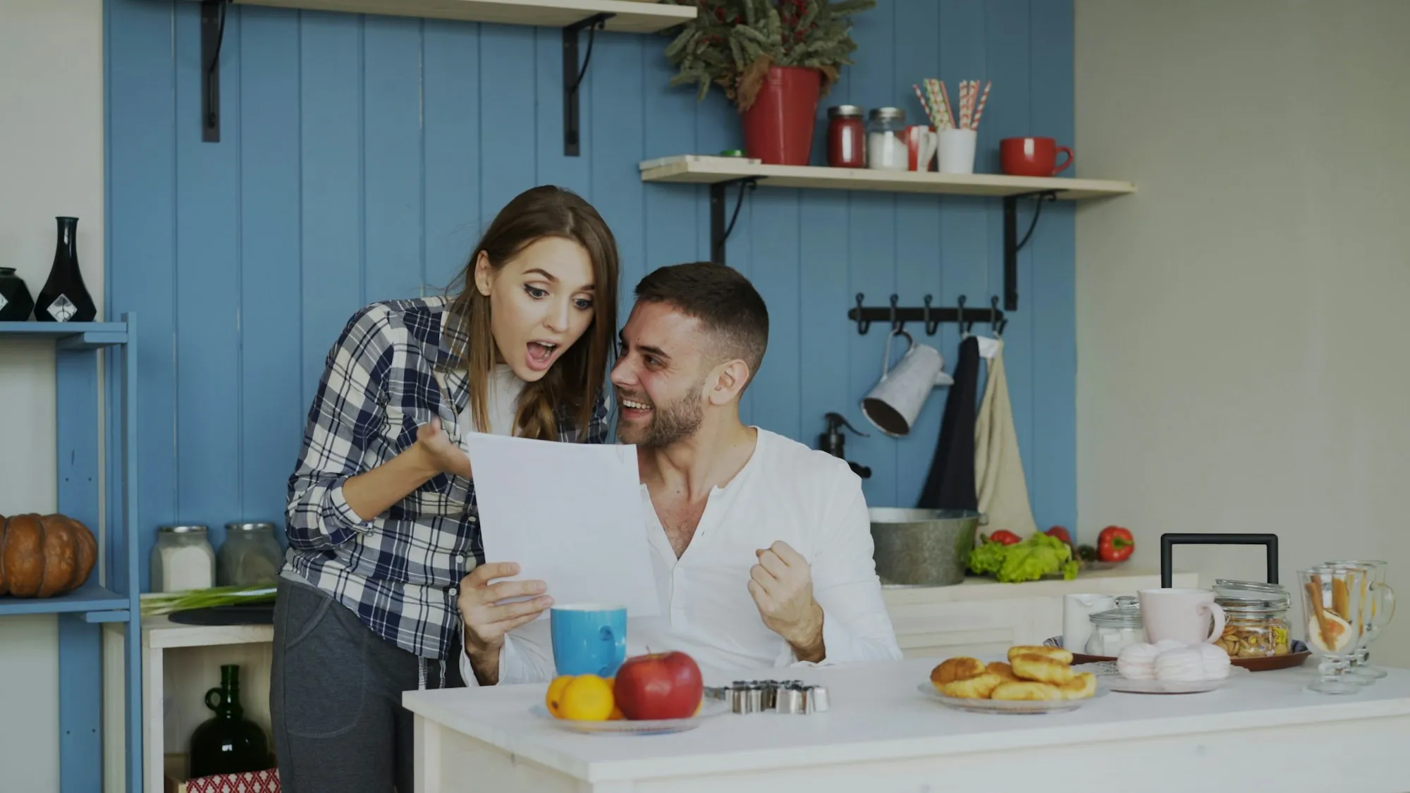 Couple reading a document together in their kitchen