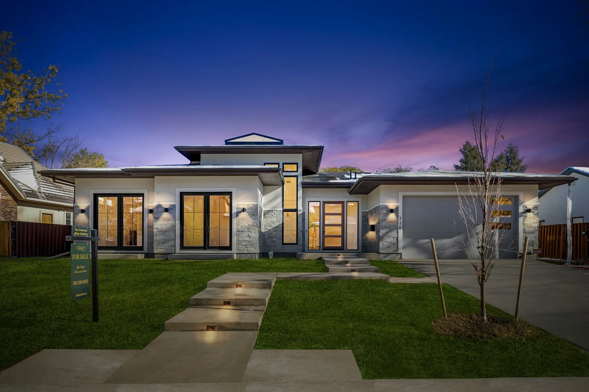 Modern single-story home with lit windows at twilight